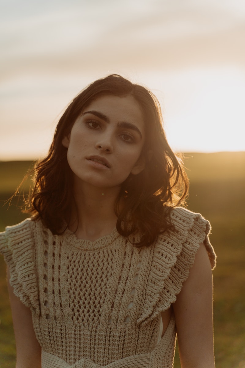 a young woman posing over the sunset