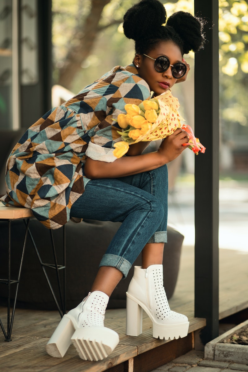 a young woman holding yellow flowers