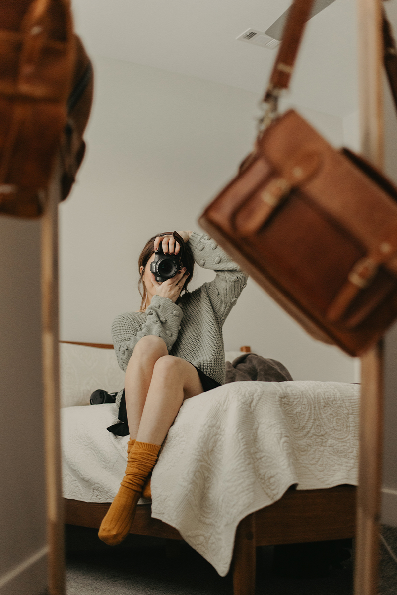 Woman on bed in socks taking a selfie