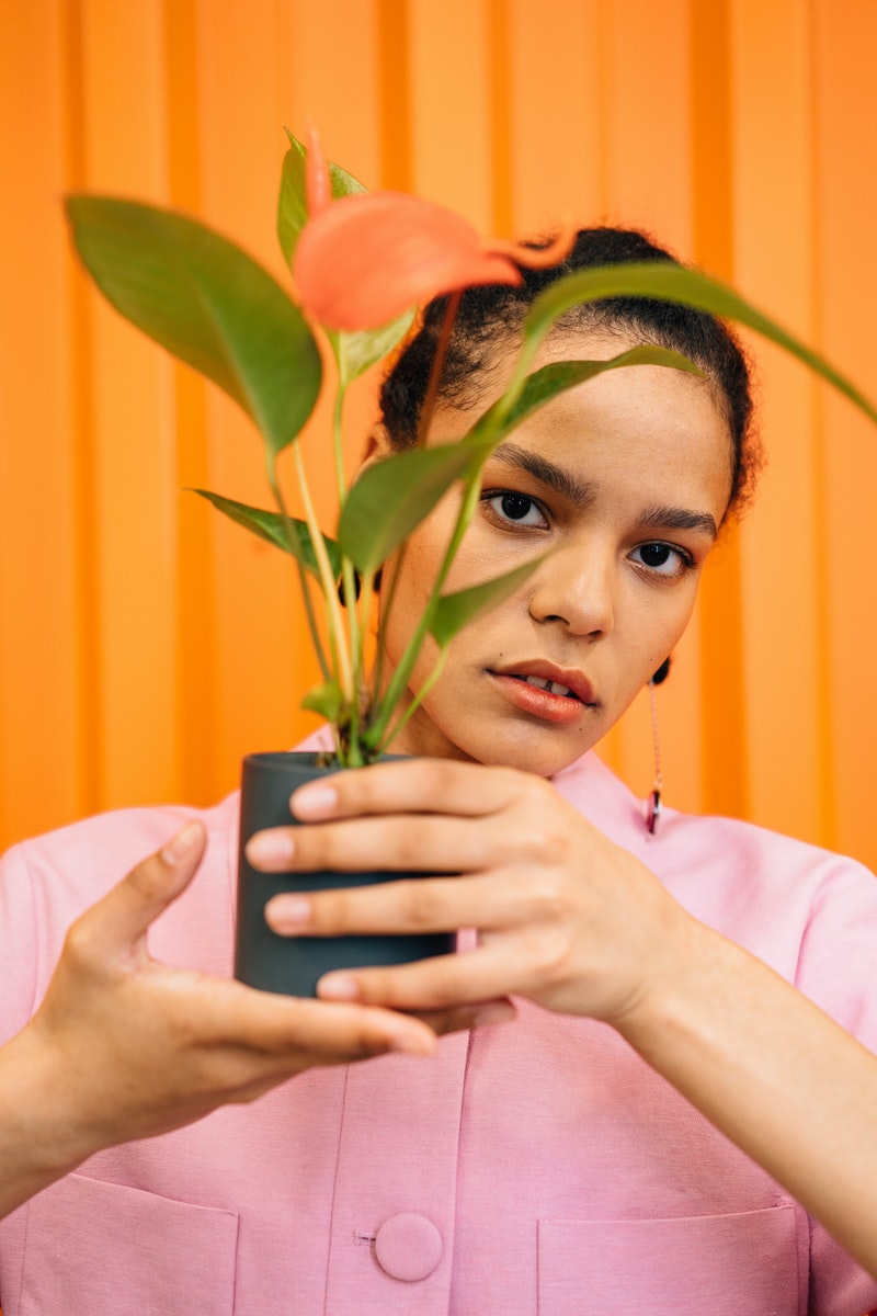 a young woman posing over orange background