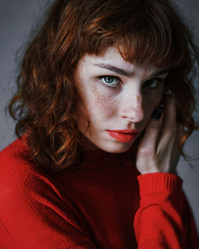 portrait photography example with a freckles woman in bright red sweater