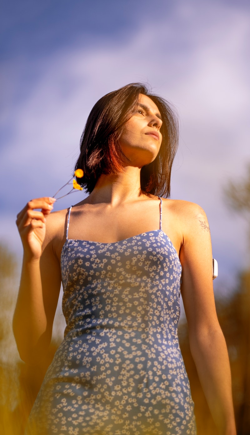 a young woman posing over in the field