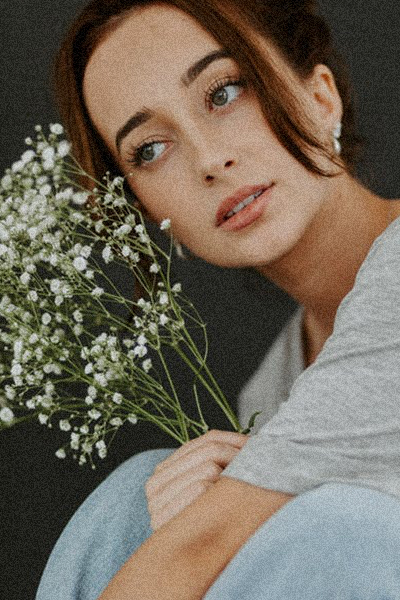 grainy photo of a girl with flowers made in a solid black background