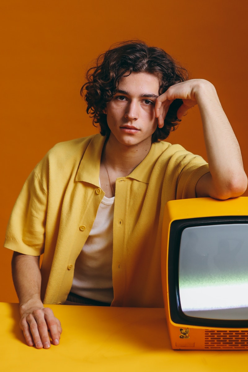 a young man posing over orange background