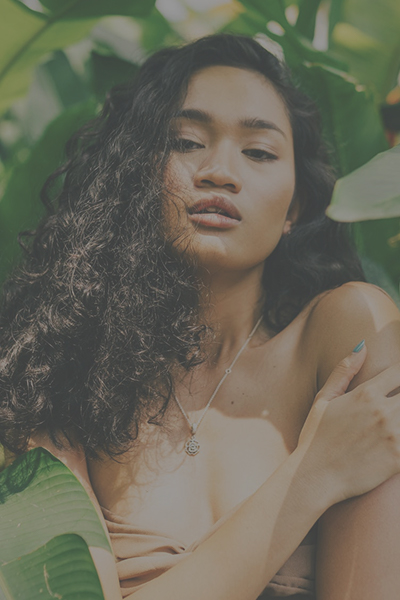 contrast tool applied to an HD photo digital photo of a brunette woman posing in the green leaves