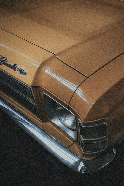 grainy picture of the hood of a retro yellow car