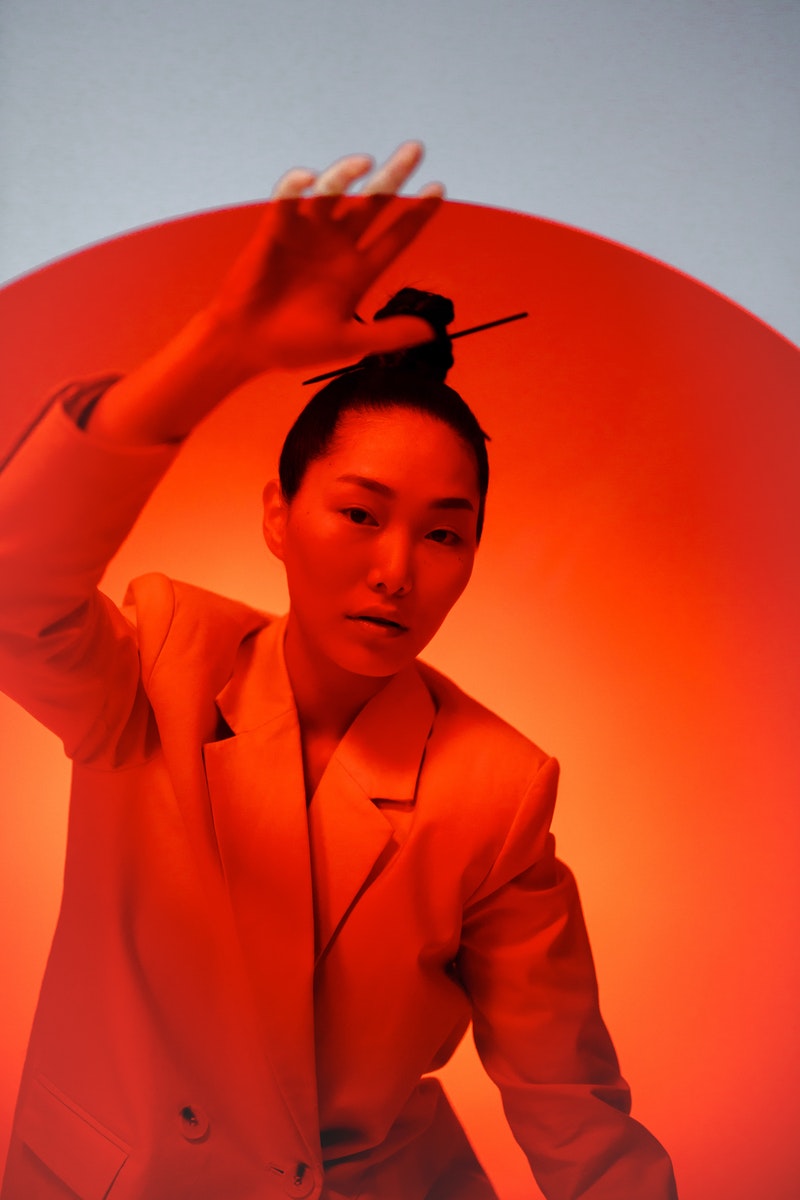 a young fashionable woman posing over orange background