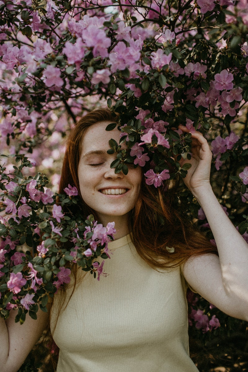a young woman posing over the flowers