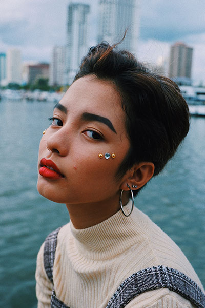 portrait photo of a girl near water with the city in the background
